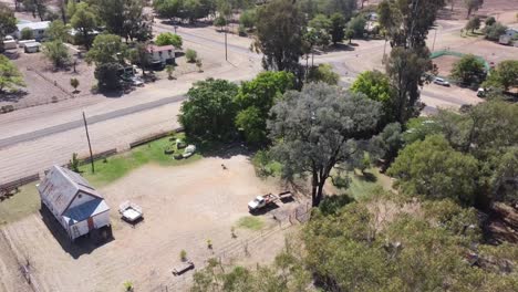 Aerial-view-of-a-small-country-Catholic-Church-surrounded-by-trees-and-solar-panels-on-top