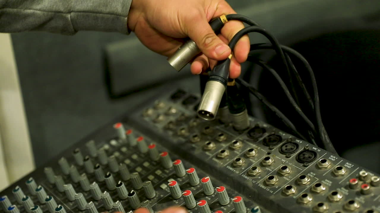 A man connecting a cable to the audio mixer - close up