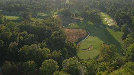 aerial flyover a beautiful golf course at sunset