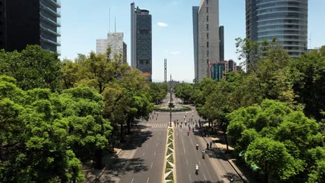 backwards drone shot of cyclists exercising on reforma avenue in mexico city