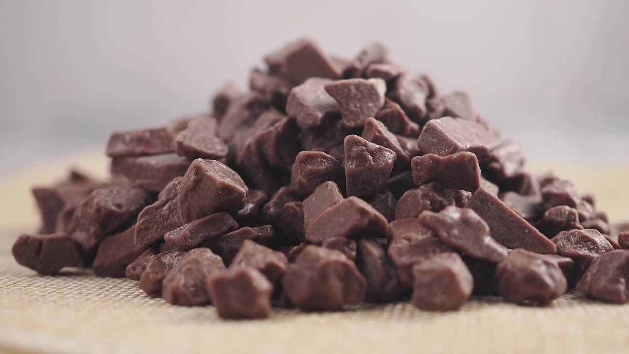 Pila di pezzi di cioccolato su una superficie texturizzata