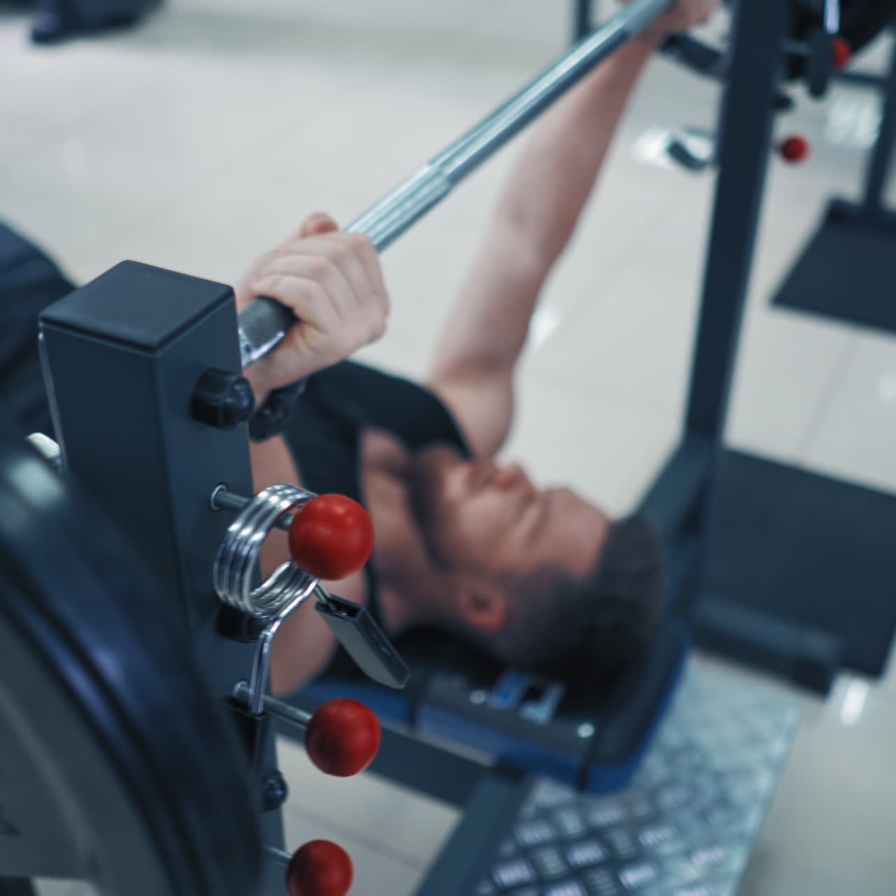 Strong bearded bodybuilder with barbell. Muscular man in black sportswear lifting up heavy barbell in gym. Close-up.