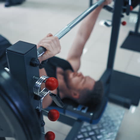strong bearded bodybuilder with barbell. muscular man in black sportswear lifting up heavy barbell in gym. close-up.
