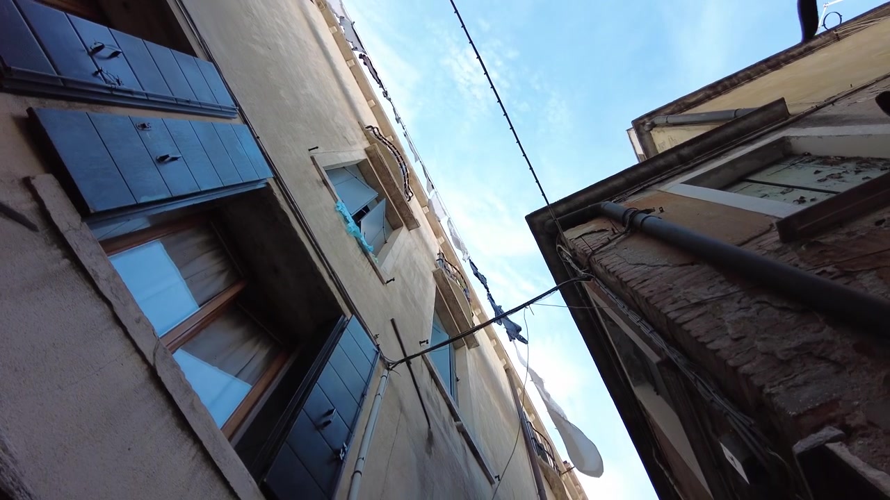 Mirando hacia arriba a los edificios y el cielo, caminando por los callejones y calles de Venecia, Italia.
