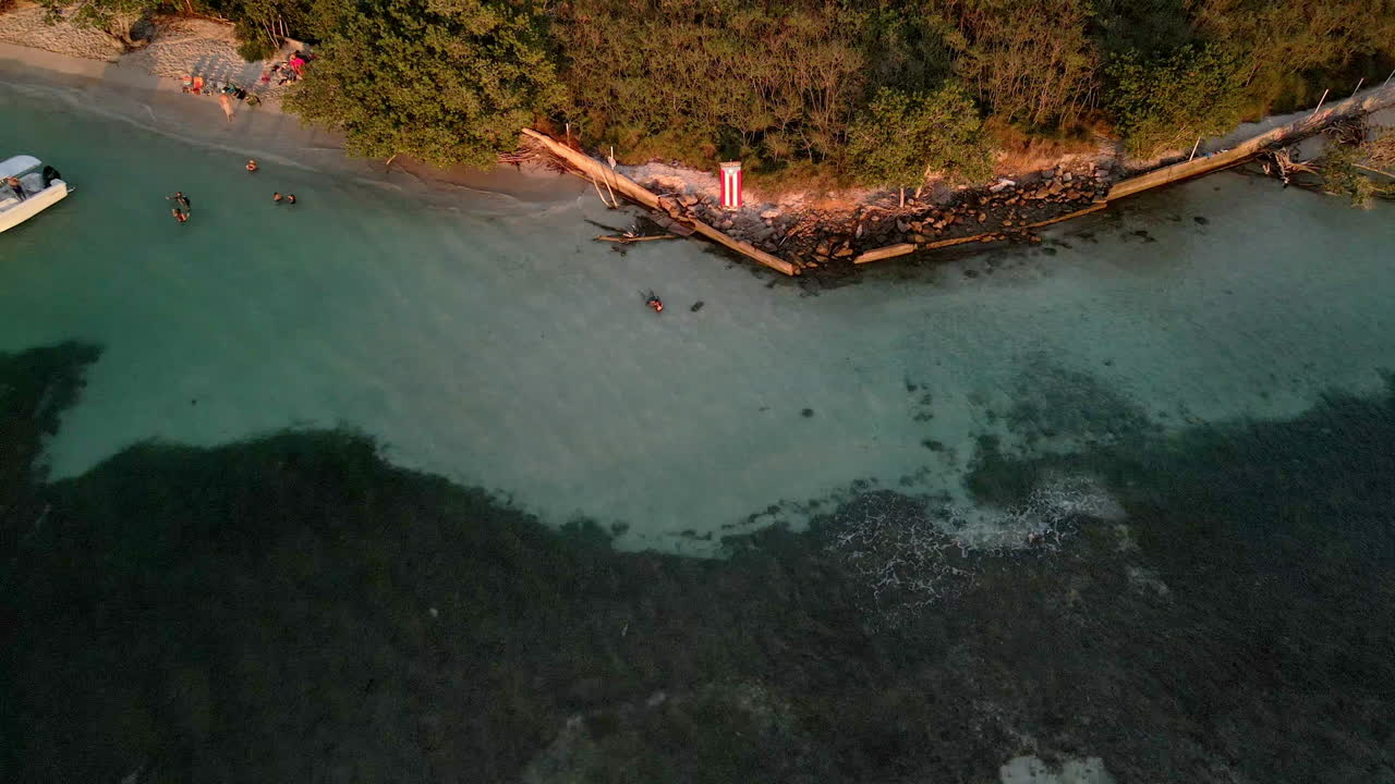 video de la bandera de puerto rico con drones hacia atrás en la playa de la hora dorada