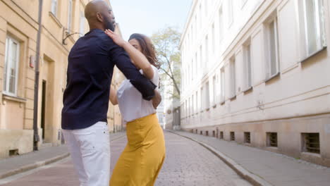 feliz pareja interracial bailando bachata en la calle del casco antiguo 5