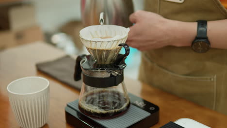 man drip coffee brewing at shop - close-up