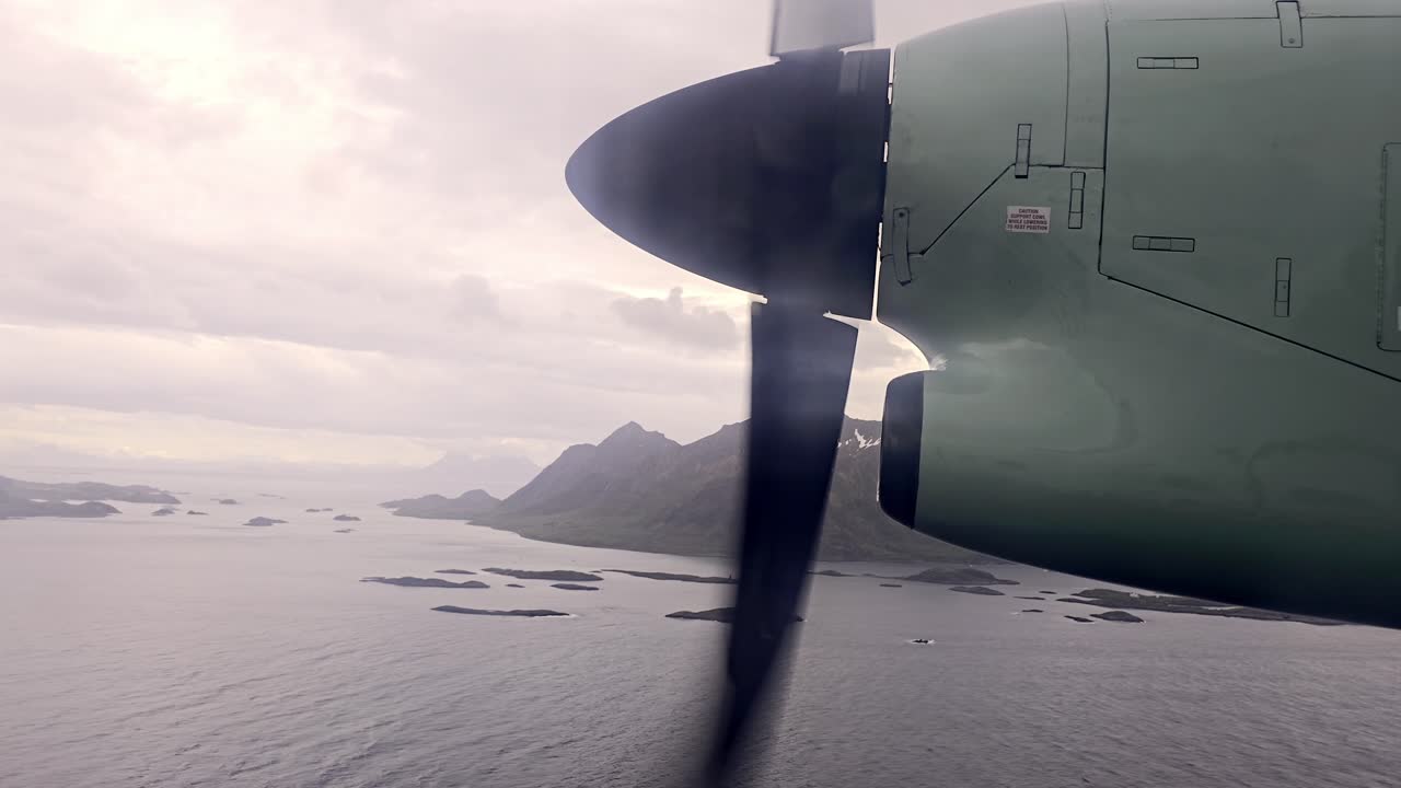 Looking out to spinning propeller over sea and islets near Svolvaer, with Lofoten peaks behind