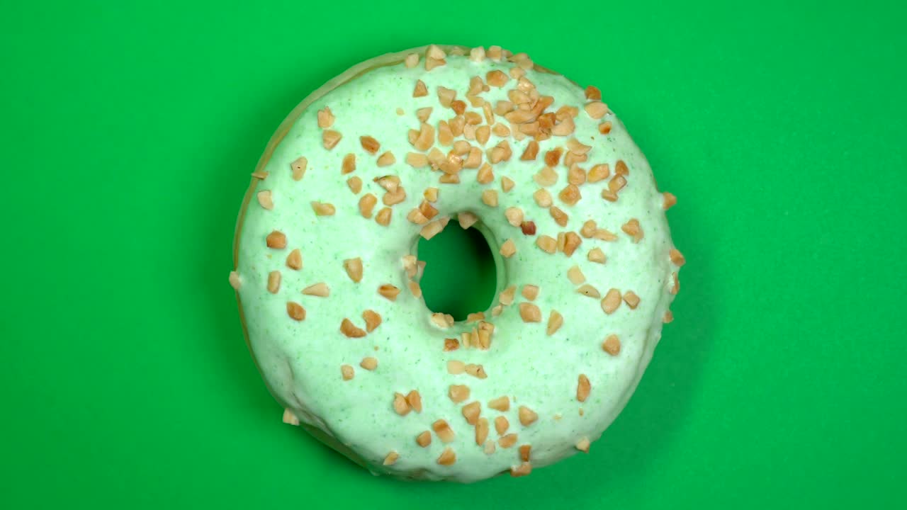 delicioso y fresco rosquilla de rosquilla macro disparo de primer plano girando sobre un fondo verde.
