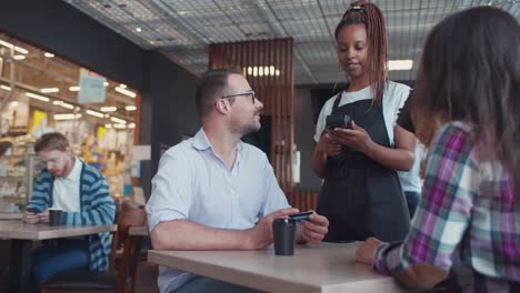 man paying for lunch with girlfriend in restaurant using credit card. realtime.