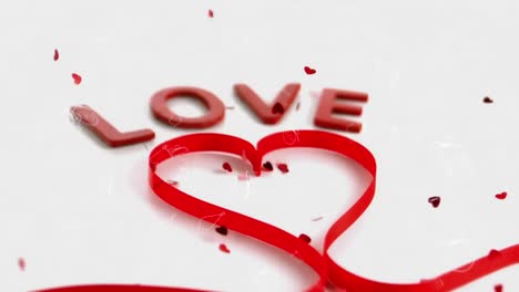 animación de la palabra amor y forma de corazón de cinta roja, con corazones rojos cayendo sobre fondo blanco