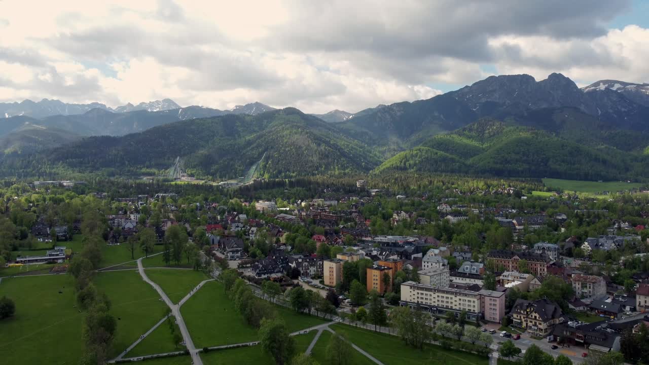sobrevuelo de zakopane, polonia, un pueblo turístico con arquitectura goral tradicional cerca de las montañas polacas tatra, tierras de cultivo, bosques, pico giewont y gran salto de esquí krokiew - seguimiento de 4k hacia adelante