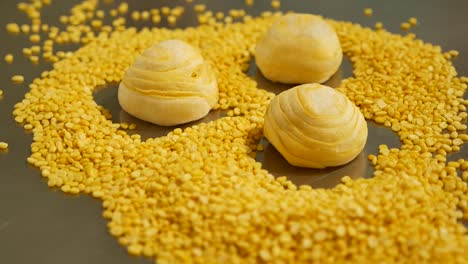 テーブルの上に黄色の中華菓子と皮をむいた緑豆、接写-2