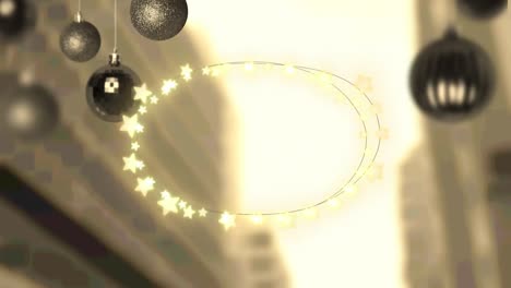 Yellow-star-shaped-fairy-lights-and-hanging-bauble-decorations-against-aerial-view-of-cityscape