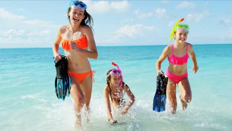 caucasian girls on tropical beach vacation going snorkeling