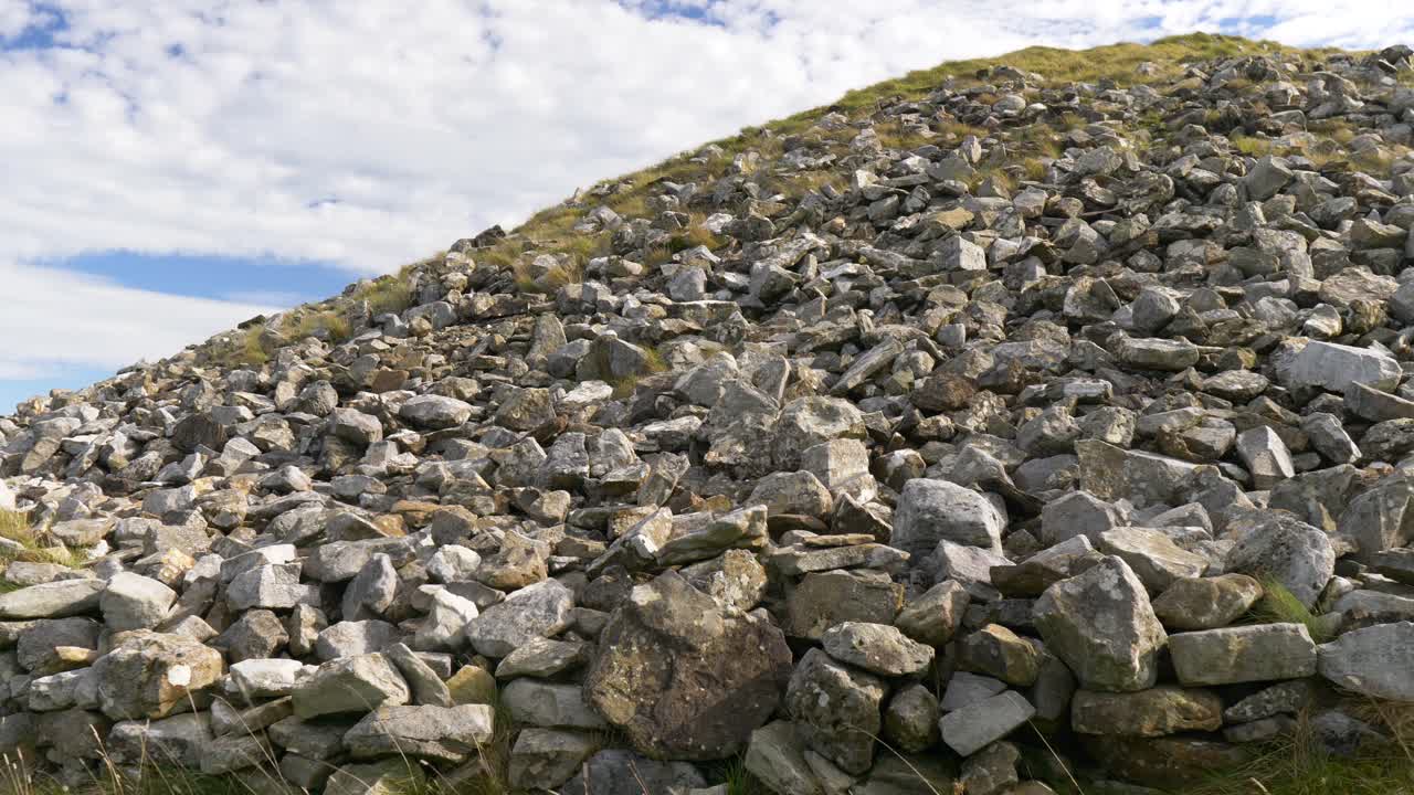 Ancient stone tomb in Loughcrew, Ireland under a blue sky