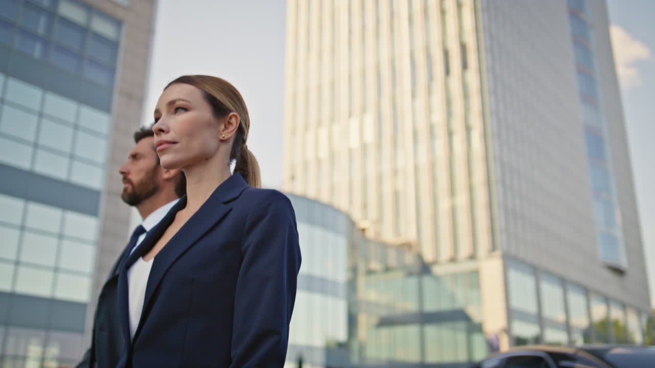 dos hombres de negocios caminando por un distrito urbano en elegantes trajes formales de cerca.