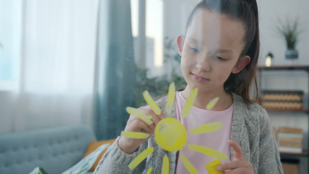 Young Girl Drawing a Sun on a Window