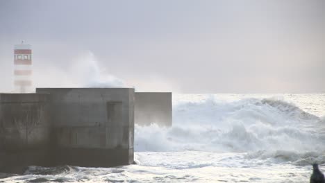 waves crushing lighthouse in porto in a cold cloudy and windy evening