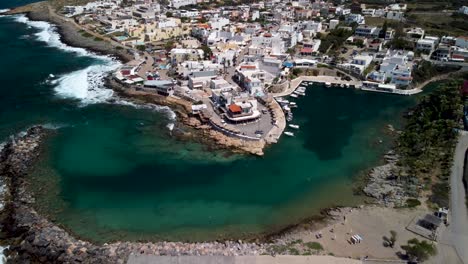 Drone-dolley-tilt-shot-of-the-large-city-Sisi-at-Crete-on-a-sunny-day