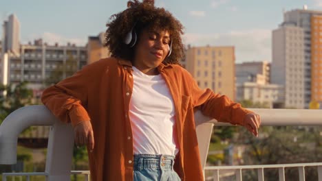 Mujer-Negra-Con-Auriculares-Y-Parada-En-El-Puente