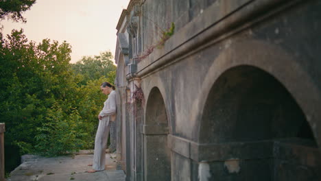 woman standing castle roof enjoying abandoned place. lady leaning on old wall