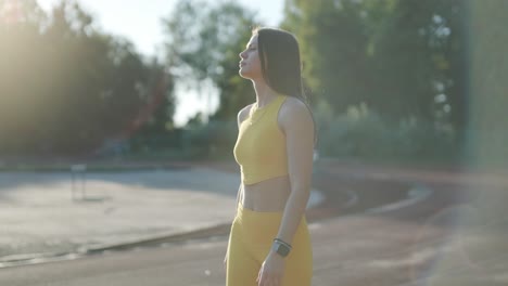 mujer en ropa deportiva amarilla en una pista de atletismo