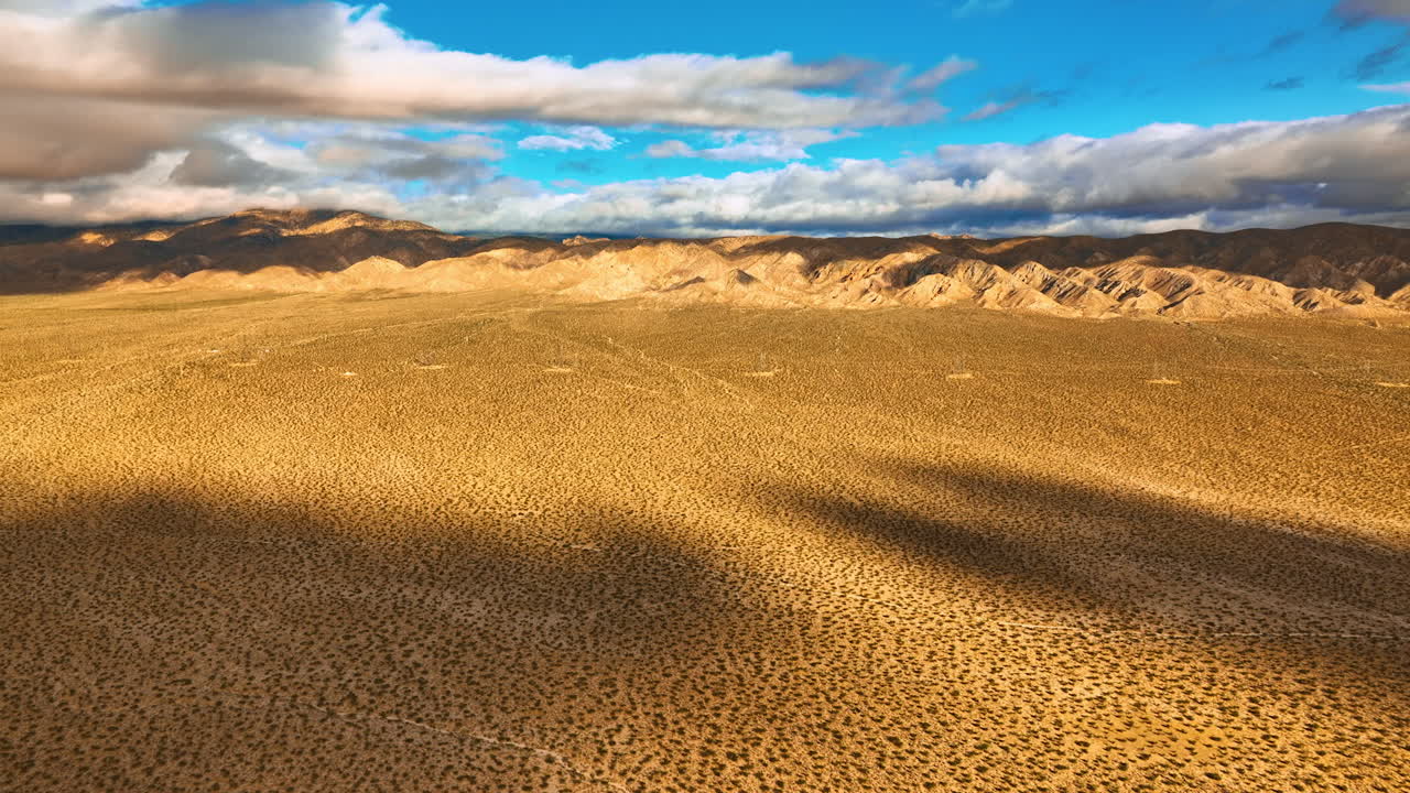 Spotted deserted landscape of Nevada on hot sunny day. Drone rising above the scenery. Rocks covered with clouds at backdrop.