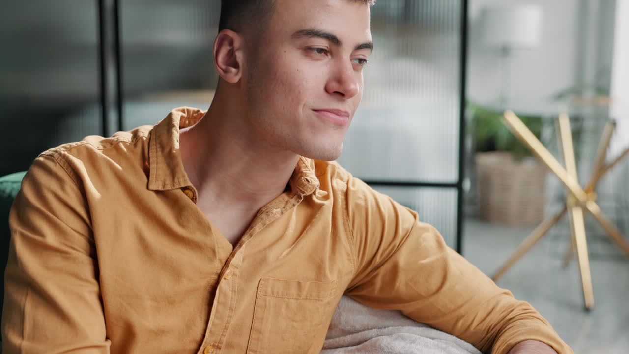 Man sitting indoors looking away and smiling