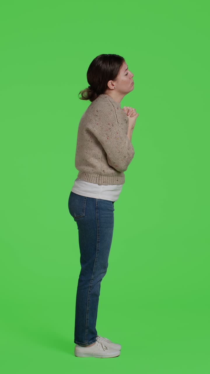 Vertical video: Profile of religious person doing prayer hands symbol on full body green screen