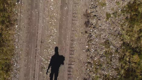 vista del avión no tripulado: silueta de una persona caminando por el camino del bosque en la isla de hiiumaa - toma dinámica cinematográfica