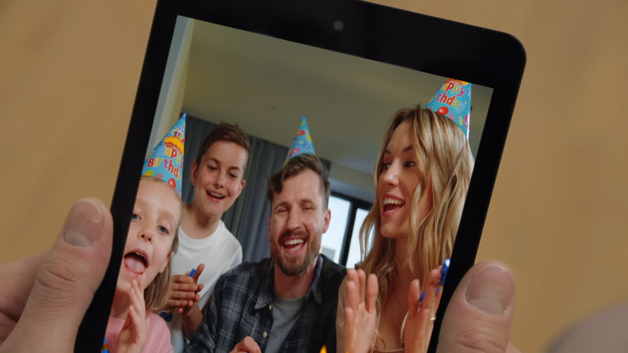 Primeiro plano de um homem desconhecido em um bate-papo por vídeo com sua família em casa usando um tablet. Homem segurando um tablet.