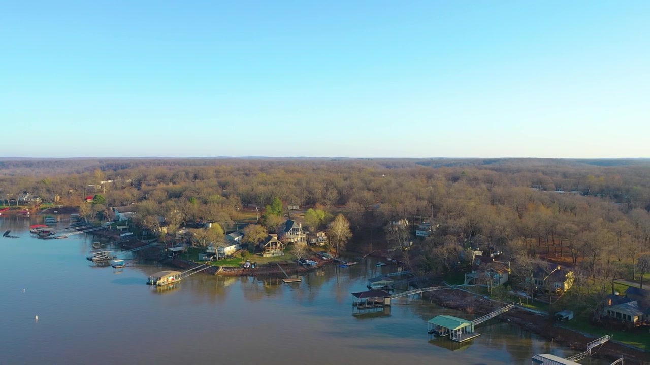 Luftfoto av Table Rock Lake i Missouri, som viser hus ved innsjøen, private båtplasser, stille vann, trekantede bredder og fredelig liv ved strandkanten nær en rolig vik