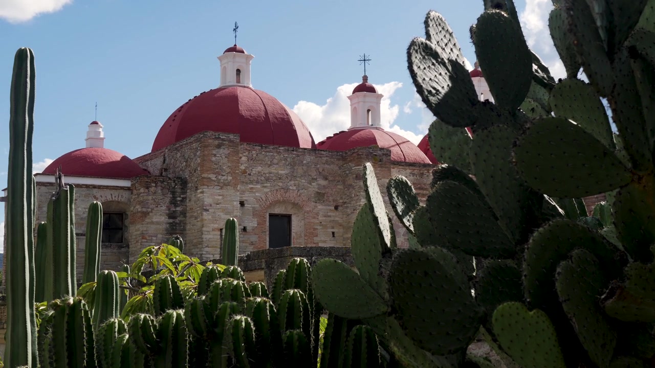 Paisagem em câmera lenta de cactos em frente à igreja-templo de San Pablo no antigo sítio arqueológico de Mitla, cidade zapoteca, Oaxaca, México, história de viagem, turismo