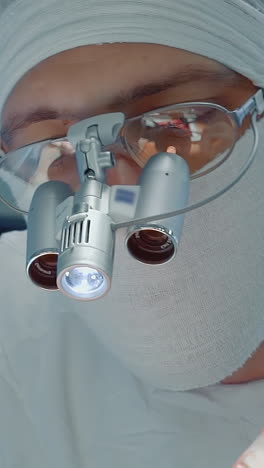 cirujano con herramienta óptica trabaja en la clínica. médico cardiólogo con máscara de gasa utiliza bisturí láser para cirugía de derivación de la arteria coronaria en el hospital