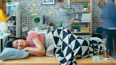 woman taking a nap in a busy office