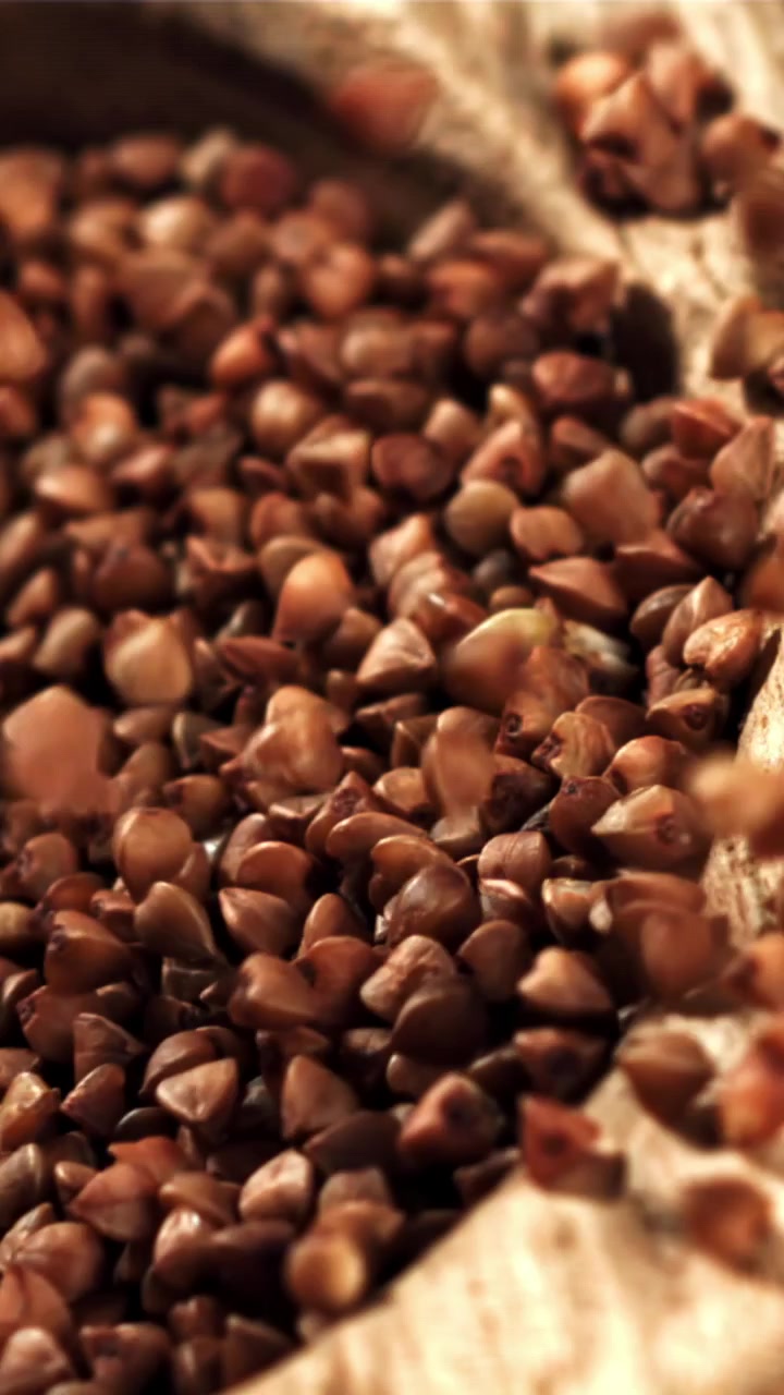 Grano saraceno crudo che si versa in una ciotola di legno rustica