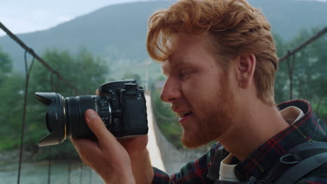 hipster de primer plano haciendo fotos usando una cámara fotográfica en la caminata por las montañas del puente del río.