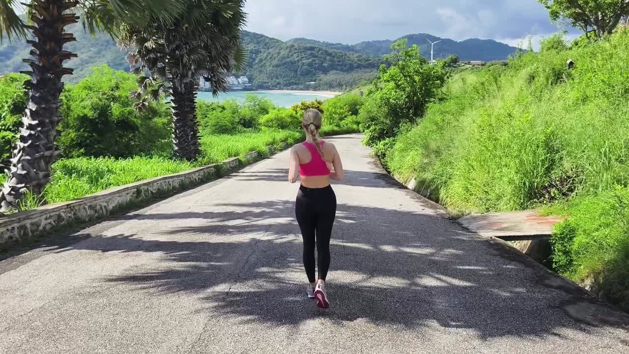mujer corriendo en una carretera panorámica con vista al océano