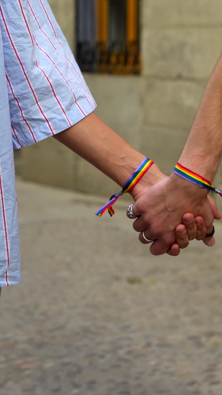 LGBTQ Couple Holding Hands with Pride Bracelets