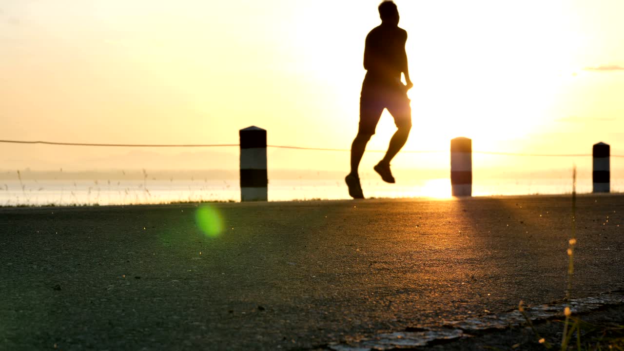 Blurred motion male runner running in the nature the time during sunrise on dam road exercise. Healthy lifestyle. Slow motion