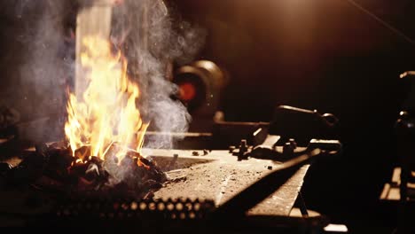 hand of blacksmith heating iron rod in fire