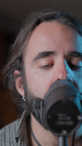 man singing into a microphone with eyes closed