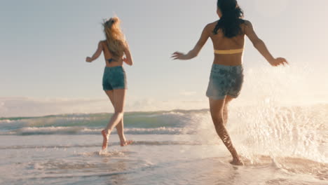 Zwei-Frauen-Am-Strand-Bespritzen-Sich-Gegenseitig-Mit-Meerwasser-Und-Haben-Spaß.-Teenager-Mädchen-Spielen-An-Einem-Warmen-Sommertag-Am-Meer-Und-Genießen-Die-Sommerferien
