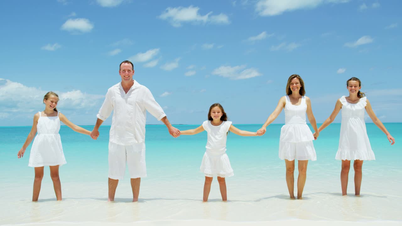 카우카시안 가족은 열대 바다의 해변에서 함께합니다.