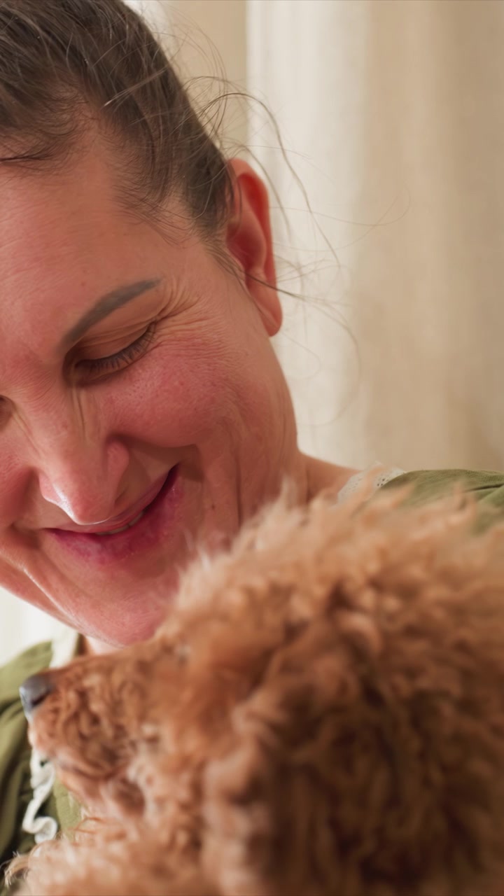 Close up of woman interacting affectionately. Camera focuses on their close proximity capturing gentle expressions. Background features light colored curtains creating calm indoor