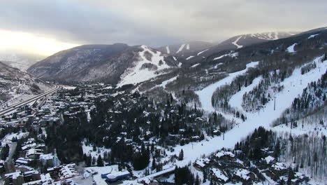 Aéreo-Cinemático-Drone-Vail-Pueblo-Estación-De-Esquí-De-Vail-Cabeza-De-Leones-Temprano-En-La-Mañana-Mediados-De-Invierno-Amanecer-De-Pistas-De-Esquí-Y-Góndola-Escénico-Paisaje-Montañoso-De-Colorado-Adelante-Revelar-Pan-Up-Movimiento