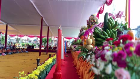 Vesak-day-procession-with-many-flowers-and-burning-candles,-motion-view