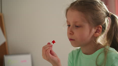 Tired-schoolgirl-looks-at-pin-with-red-flag-intently-spinning