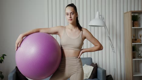 woman doing fitness exercises with a large purple ball